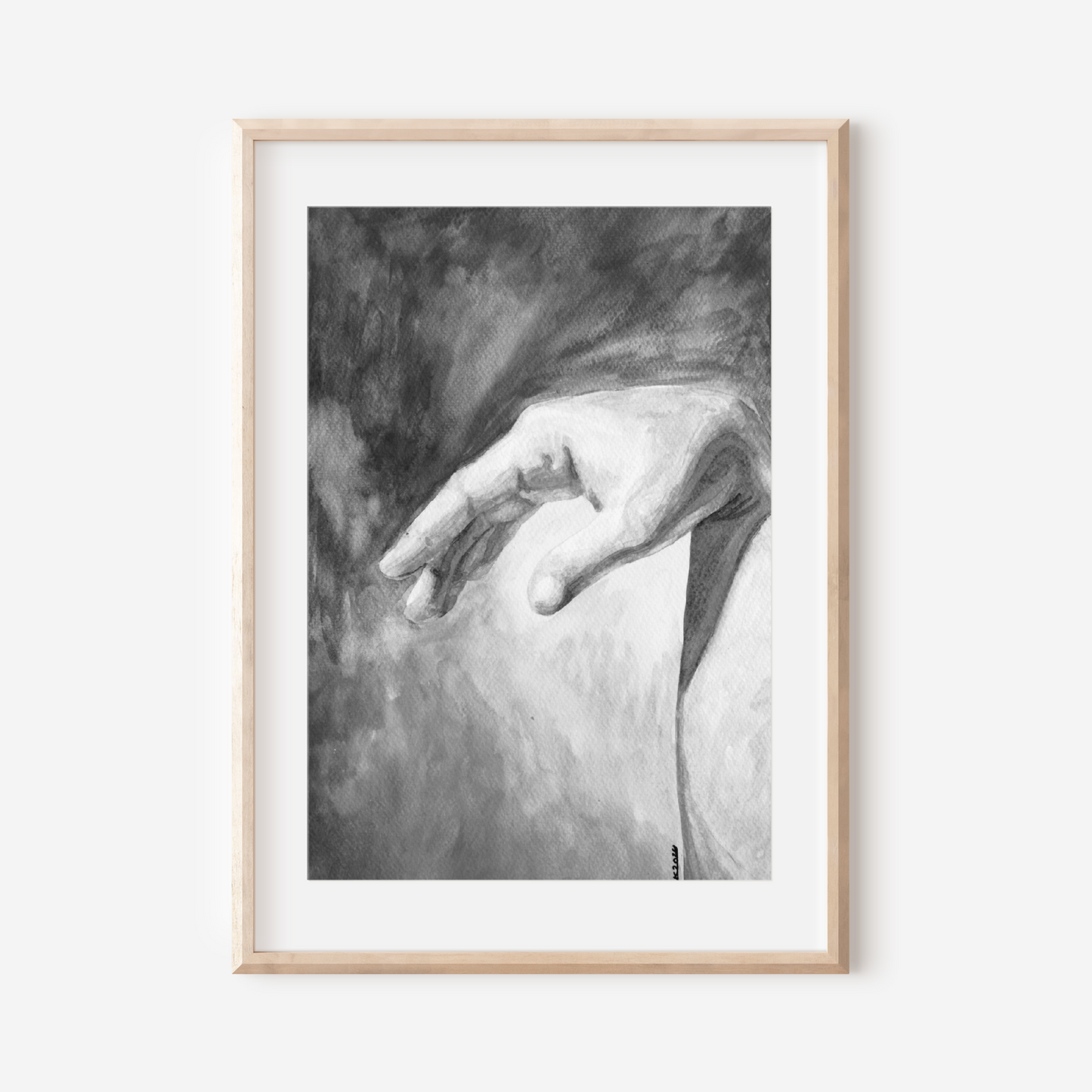Framed black and white artwork of a hand on a white wall