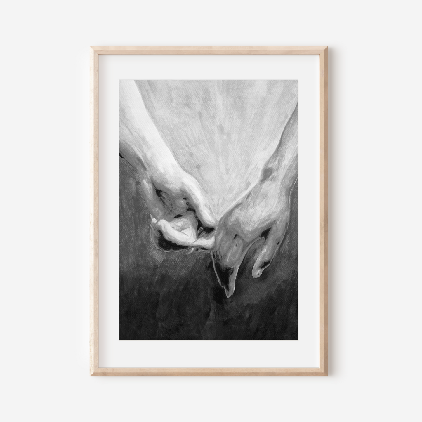 Framed black and white artwork of two hands holding each other on a white wall.