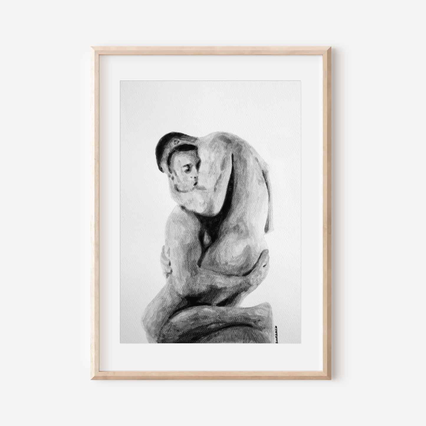 Framed black and white artwork of a nude figure on a white wall
