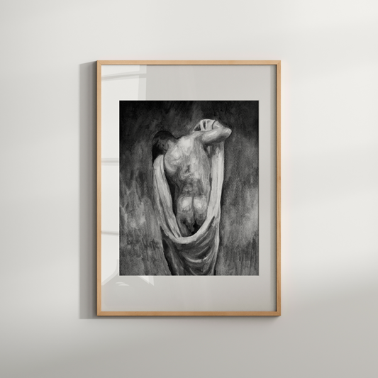 Framed black and white artwork of a draped figure on a light gray wall