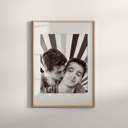 Framed black and white artwork of two people embracing on a light gray wall.