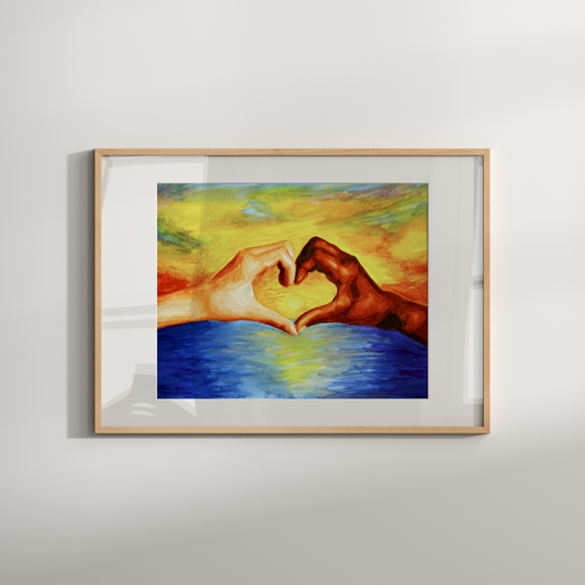 Framed artwork of two hands forming a heart shape over water on a light gray wall.