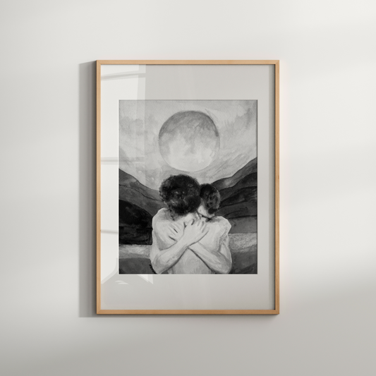 Framed artwork of a couple embracing with a mountain and moon background on a white wall.