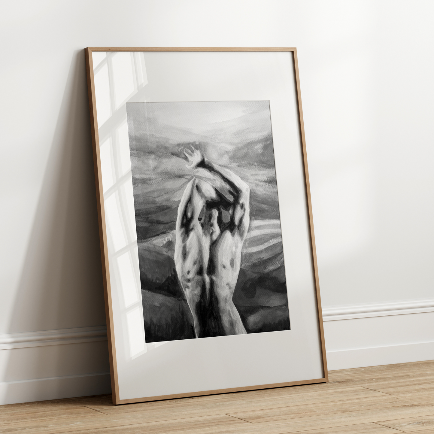 Framed black and white artwork leaning against a white wall.