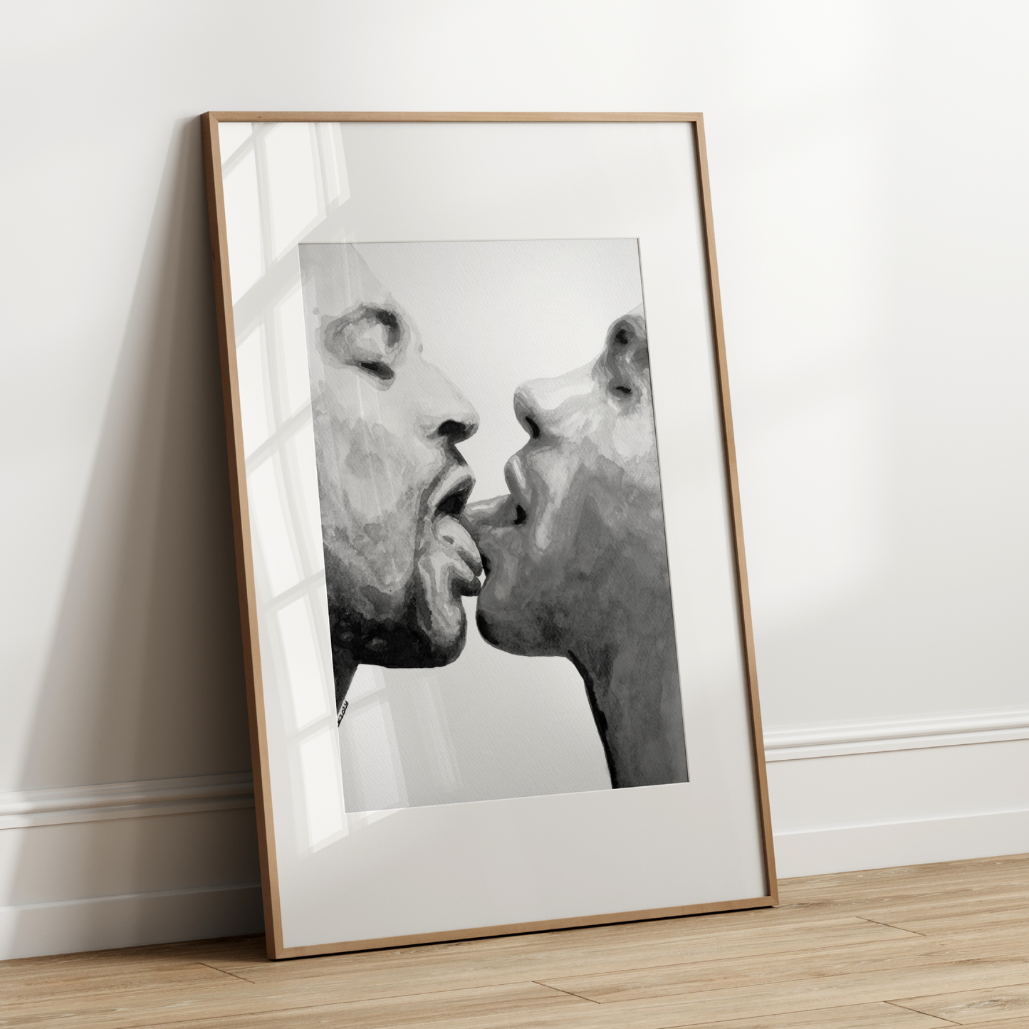 Framed black and white artwork of two faces on a white wall.