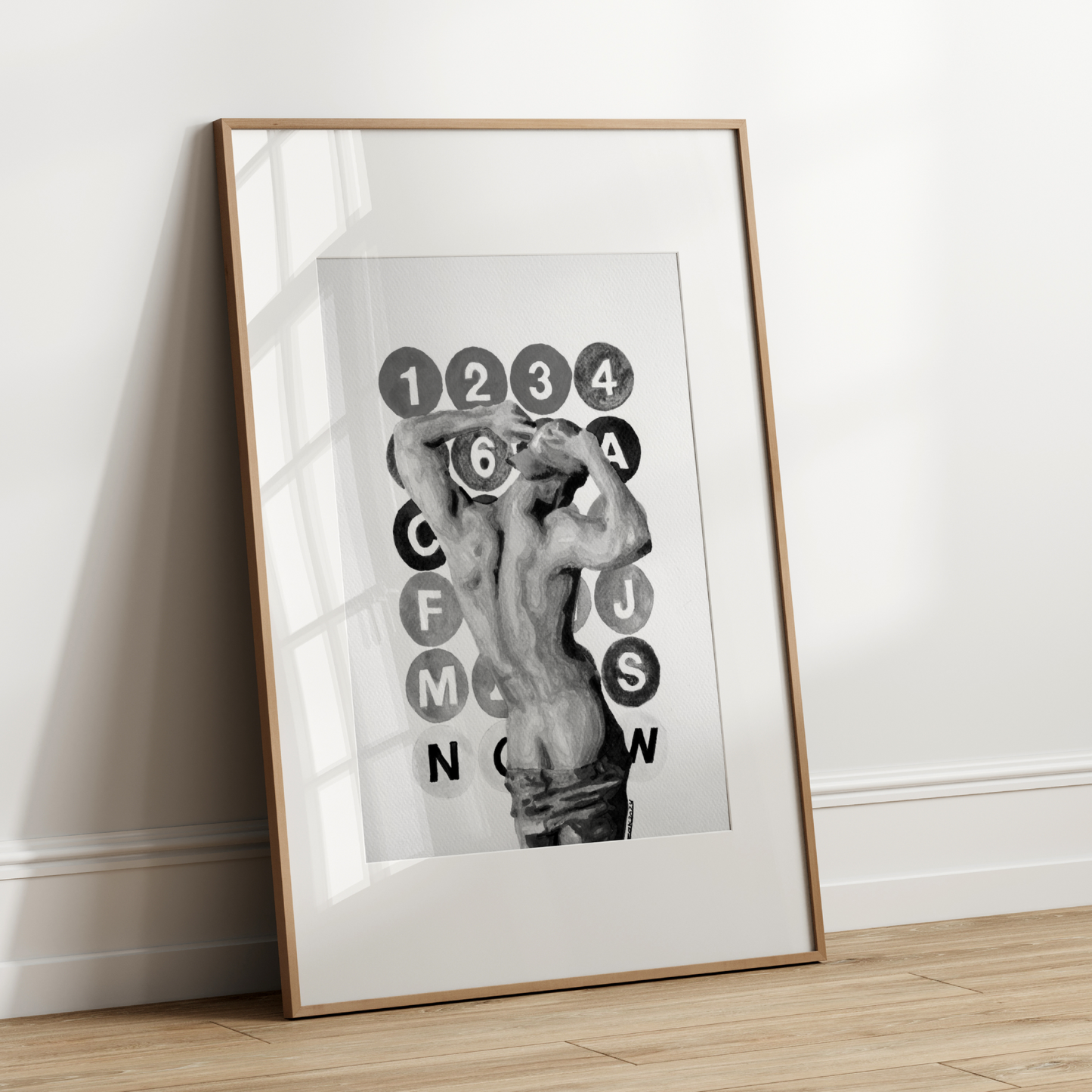 Framed artwork with a black and white design on a white wall.
