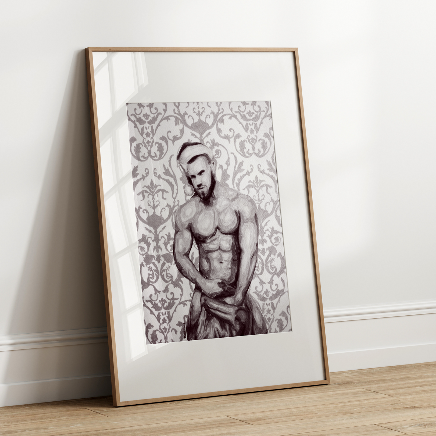Framed artwork of a shirtless man against a decorative patterned background on a white wall.