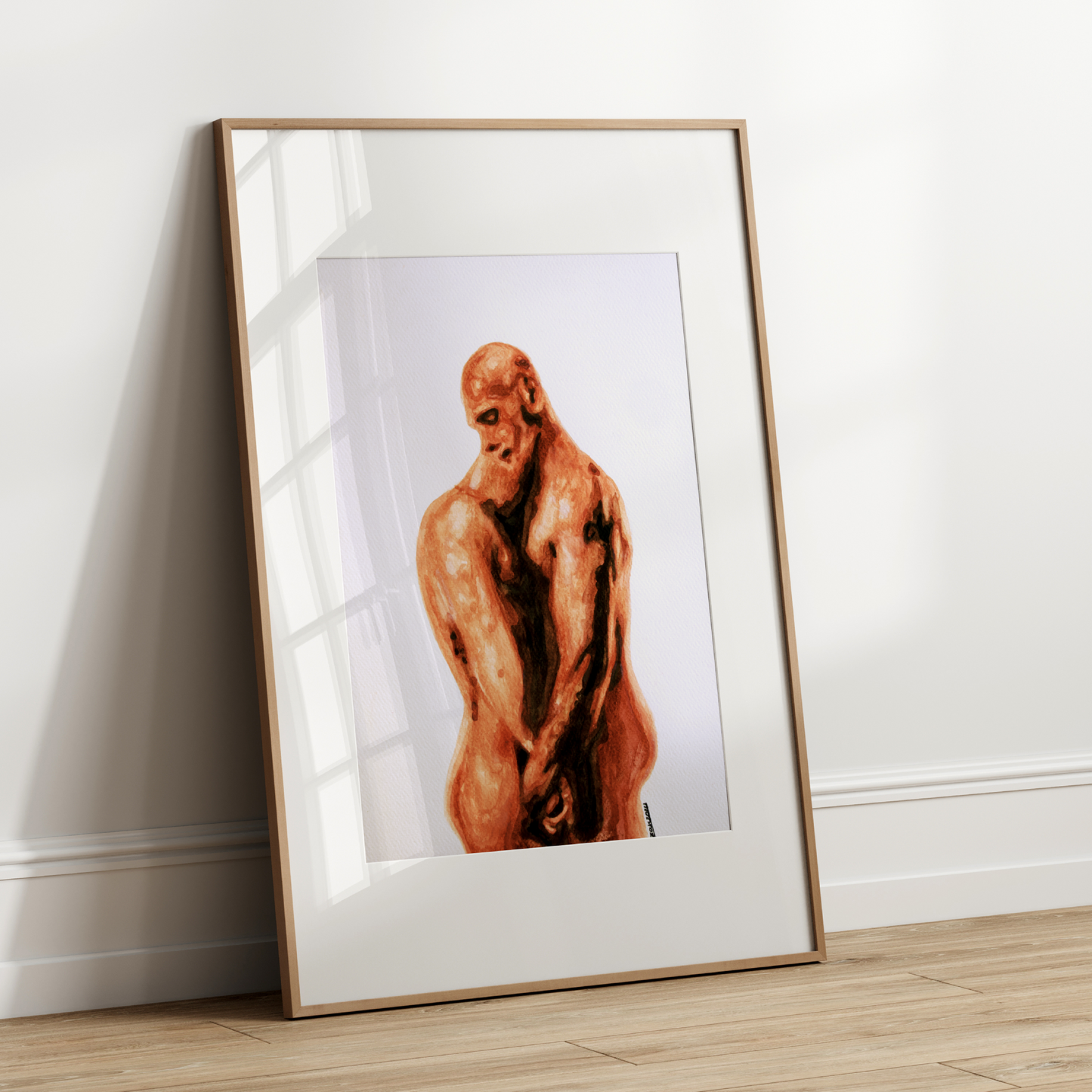 Framed artwork of a nude figure leaning against a white wall.