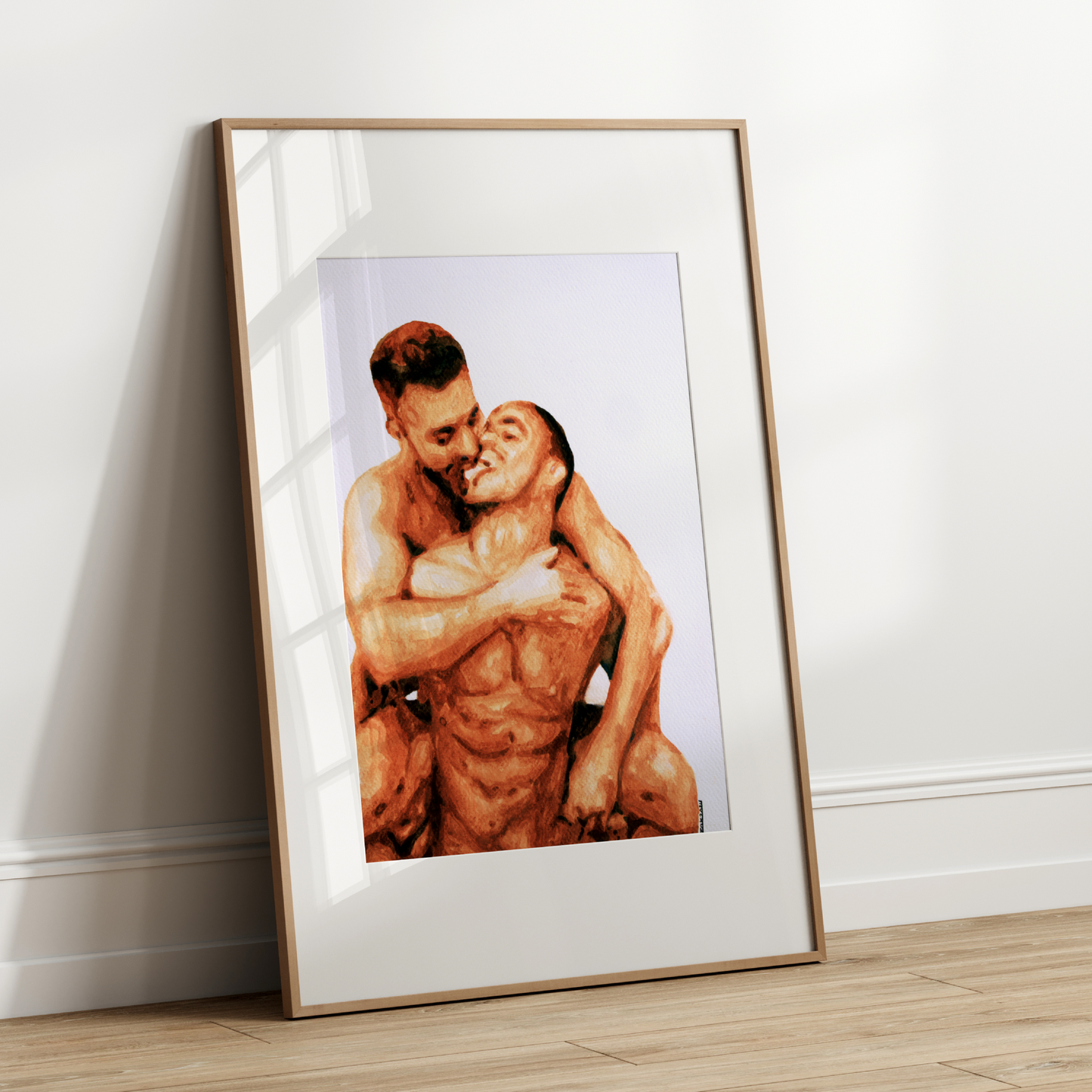Framed artwork of two people embracing on a white wall.