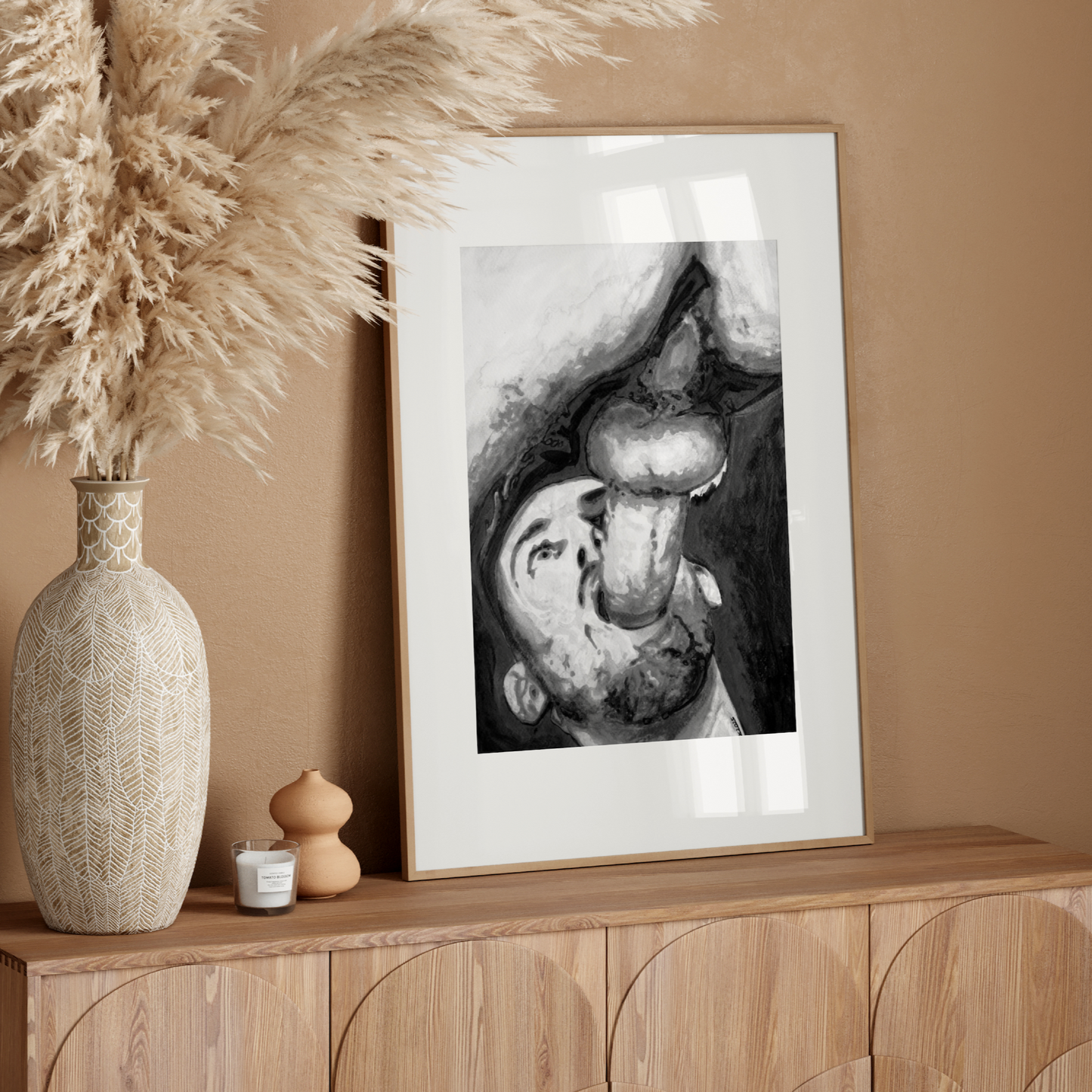 Framed artwork on a wooden console table with decorative elements against a beige wall.