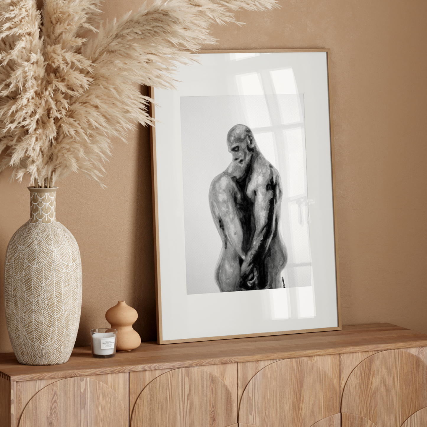 Framed artwork of a monkey on a wooden sideboard with decorative elements against a beige wall.