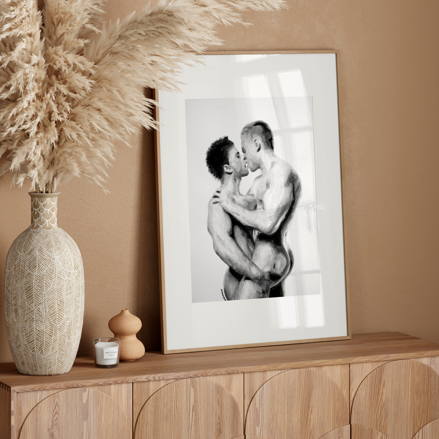 Framed black and white photograph of two people embracing on a wooden sideboard with decorative elements.
