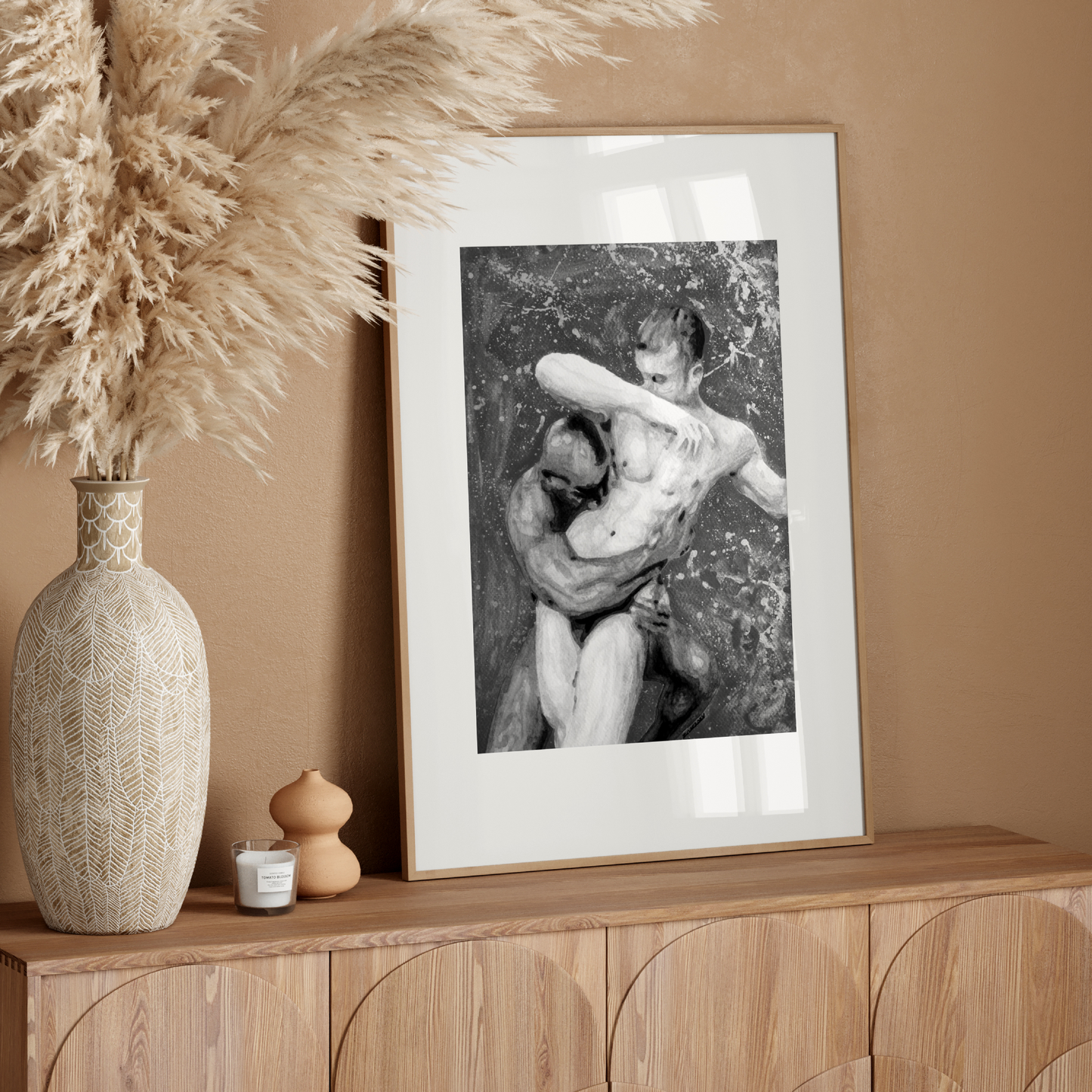 Framed black and white artwork on a wooden console table with decorative elements.
