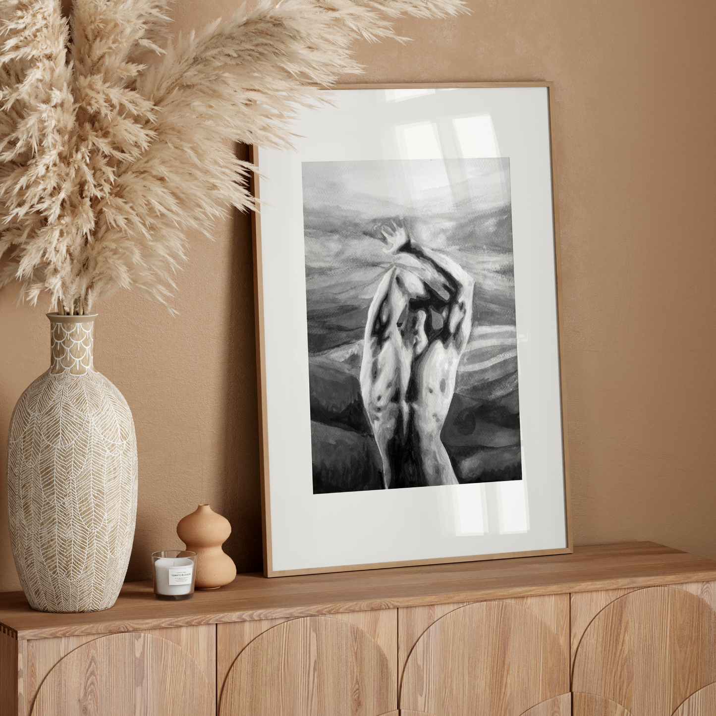 Framed black and white artwork on a wooden console table with decorative elements.