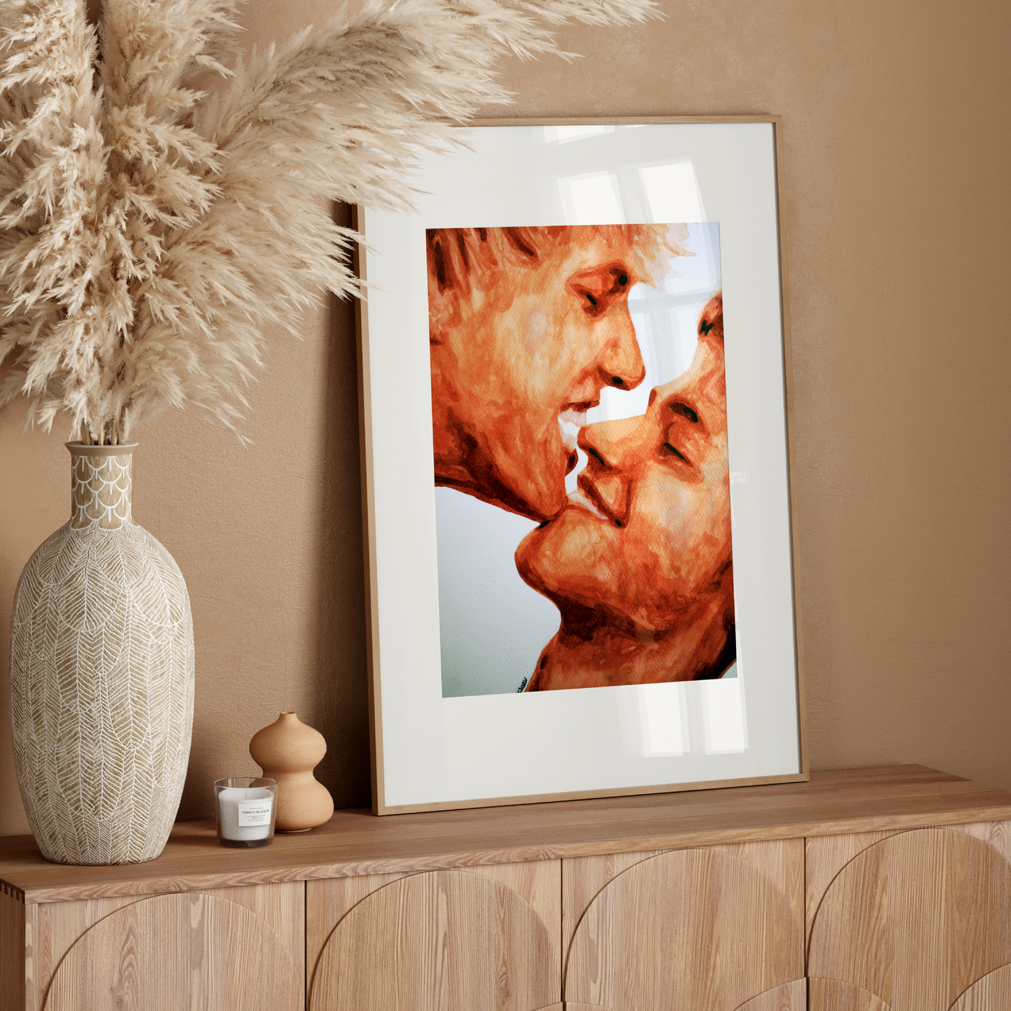 Framed artwork of two faces on a wooden sideboard with decorative elements.