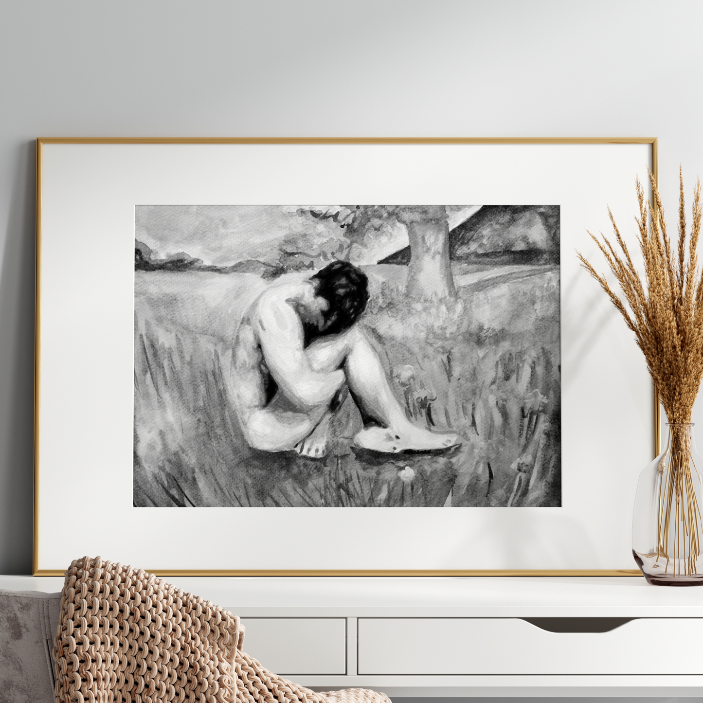 Framed black and white artwork of a nude figure on a wall above a white console table.