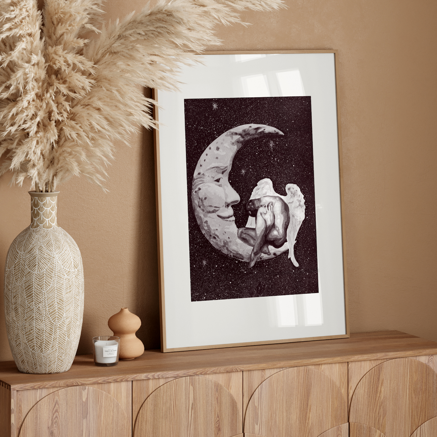 Framed artwork of a moon and star on a wooden sideboard with decorative elements.
