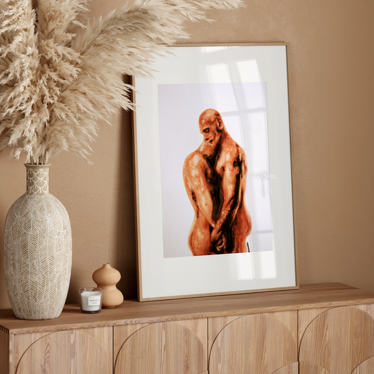 Framed artwork of a nude figure on a wooden sideboard with decorative elements.