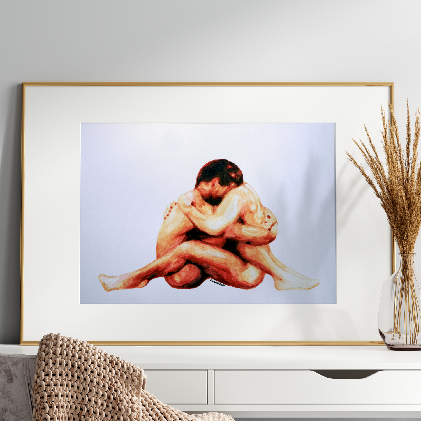 Framed artwork of two people embracing on a white console table with decorative elements.