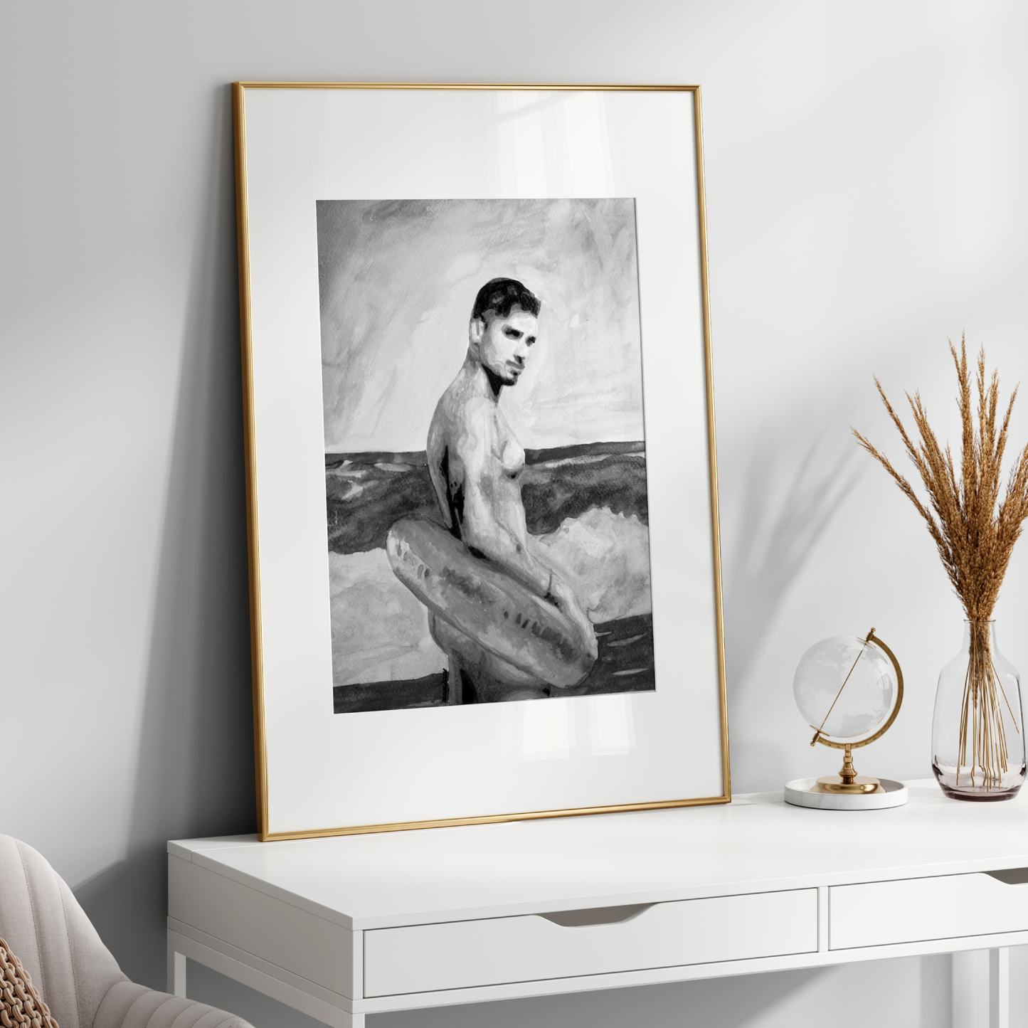 Framed black and white artwork on a white wall above a white console table with decorative items.