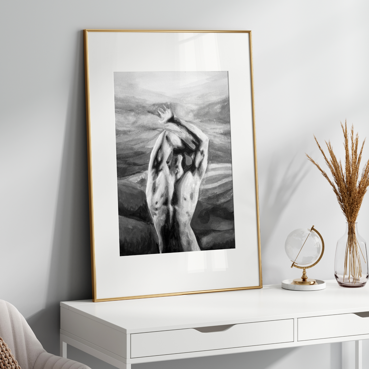 Framed black and white artwork on a white wall above a white console table with decorative items.