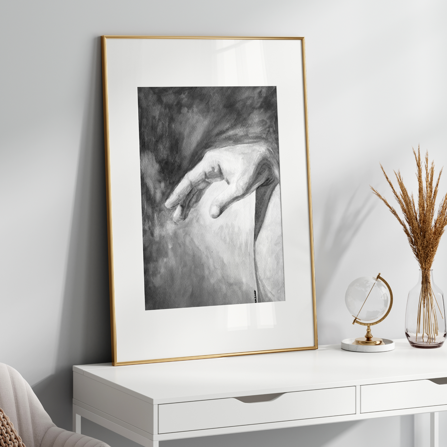 Framed black and white artwork on a white wall above a white console table with decorative items.