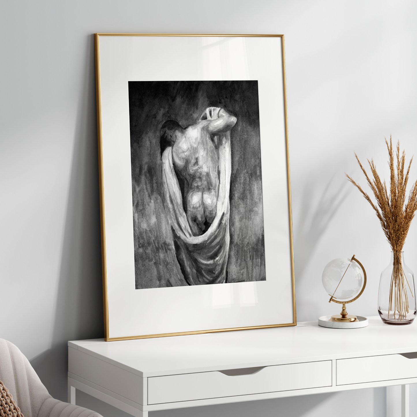 Framed black and white artwork on a white wall above a white console table.