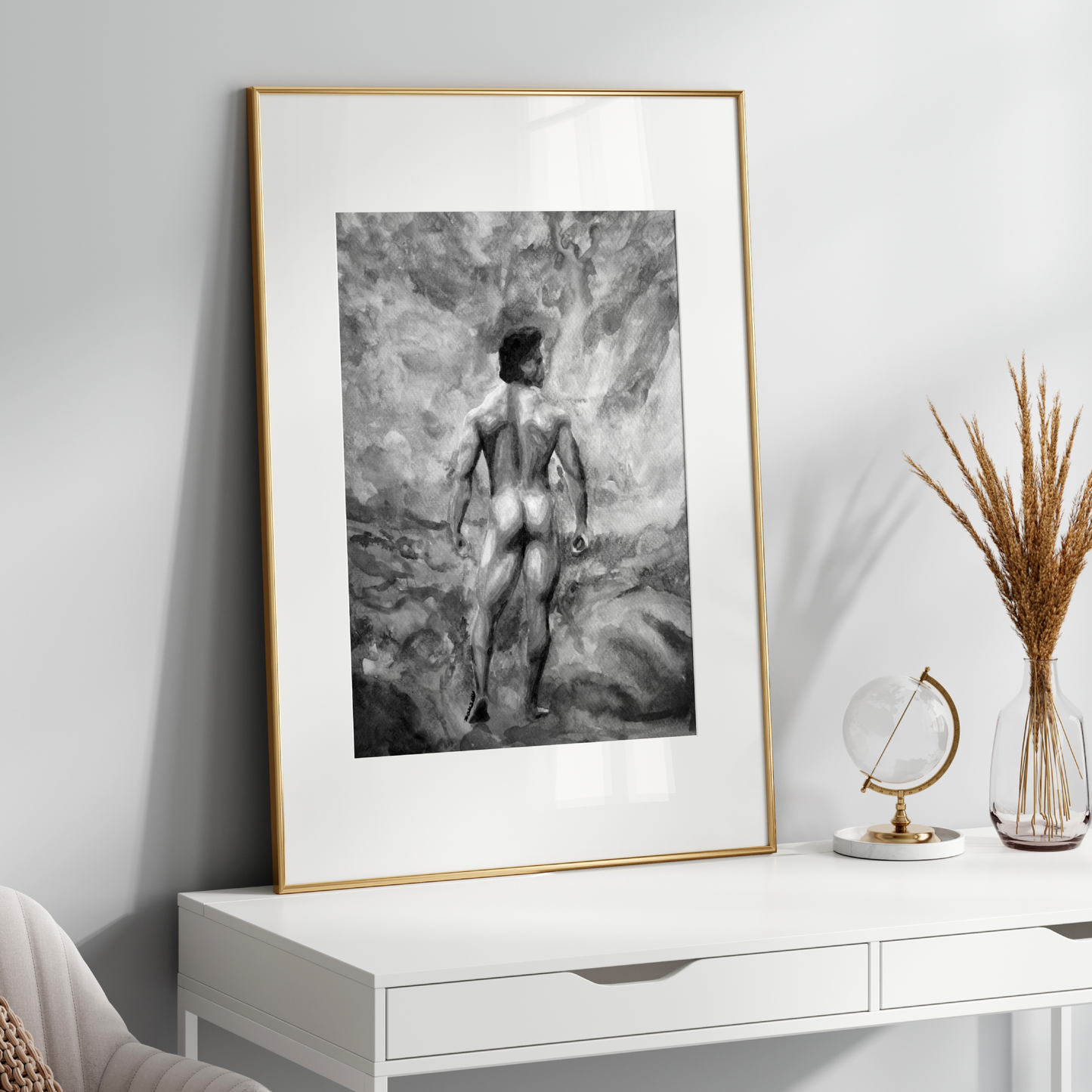 Framed black and white artwork of a nude figure on a white console table with decorative items.