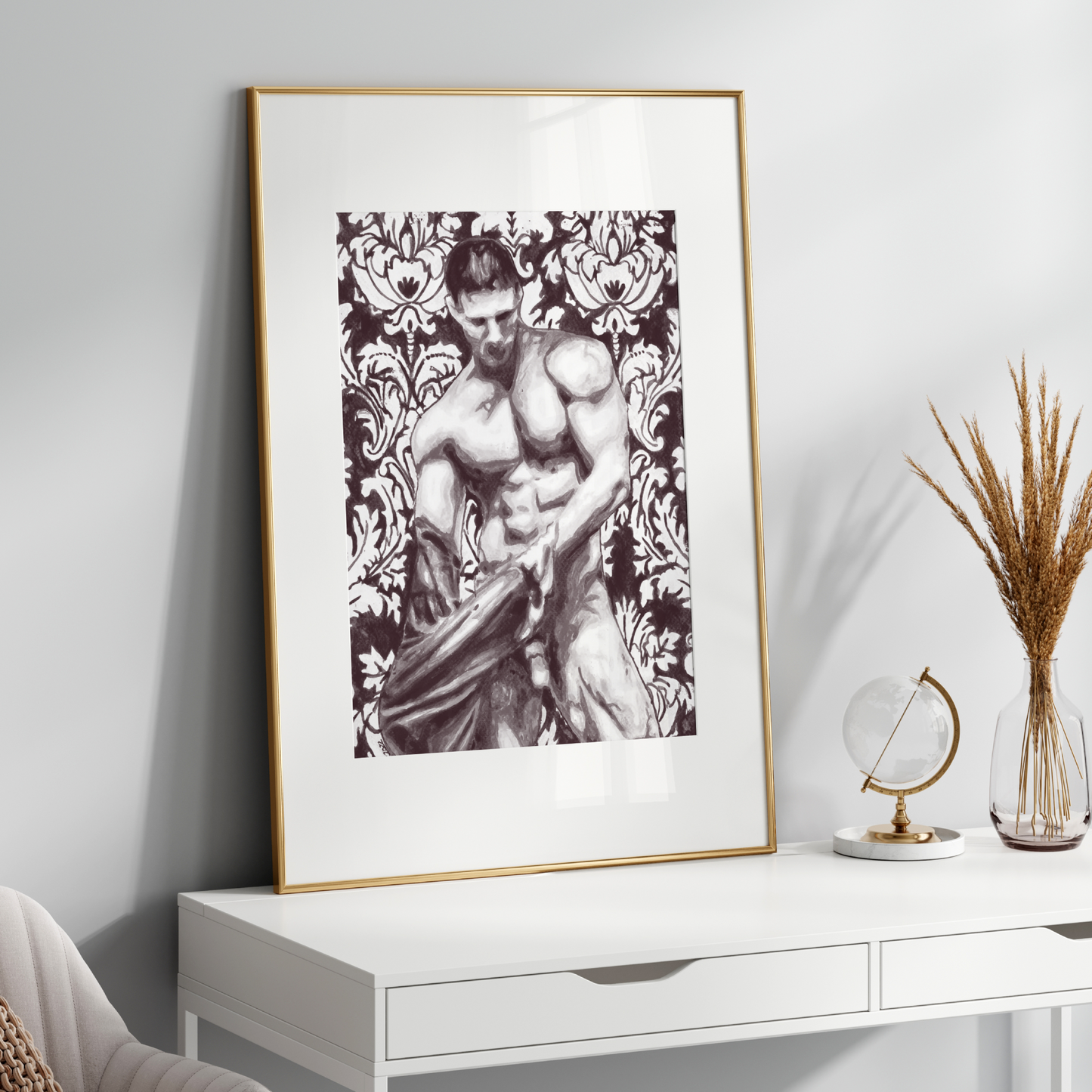 Framed artwork of a muscular figure with floral patterns on a white wall above a white console table.