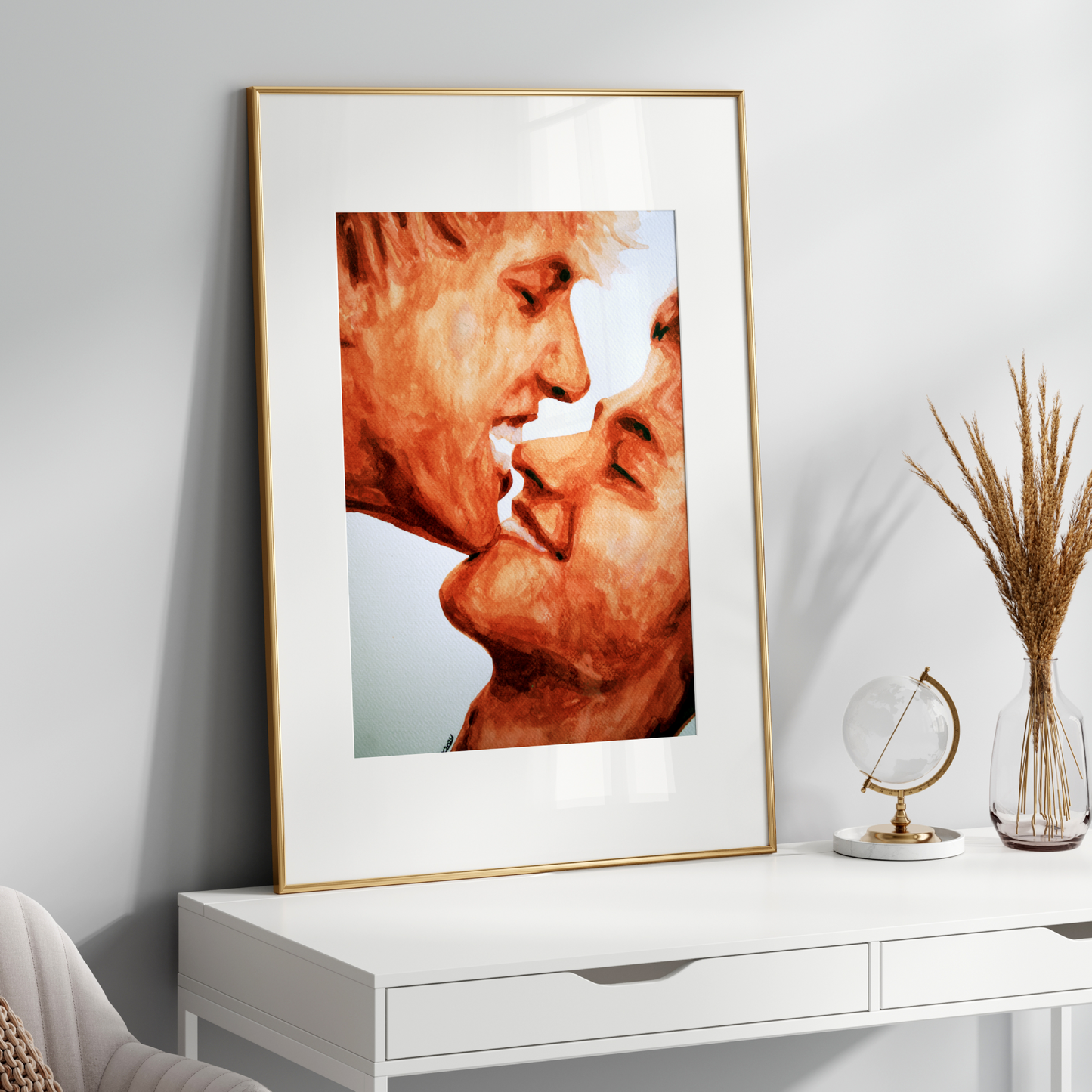 Framed artwork of two people kissing on a white console table with decorative items.