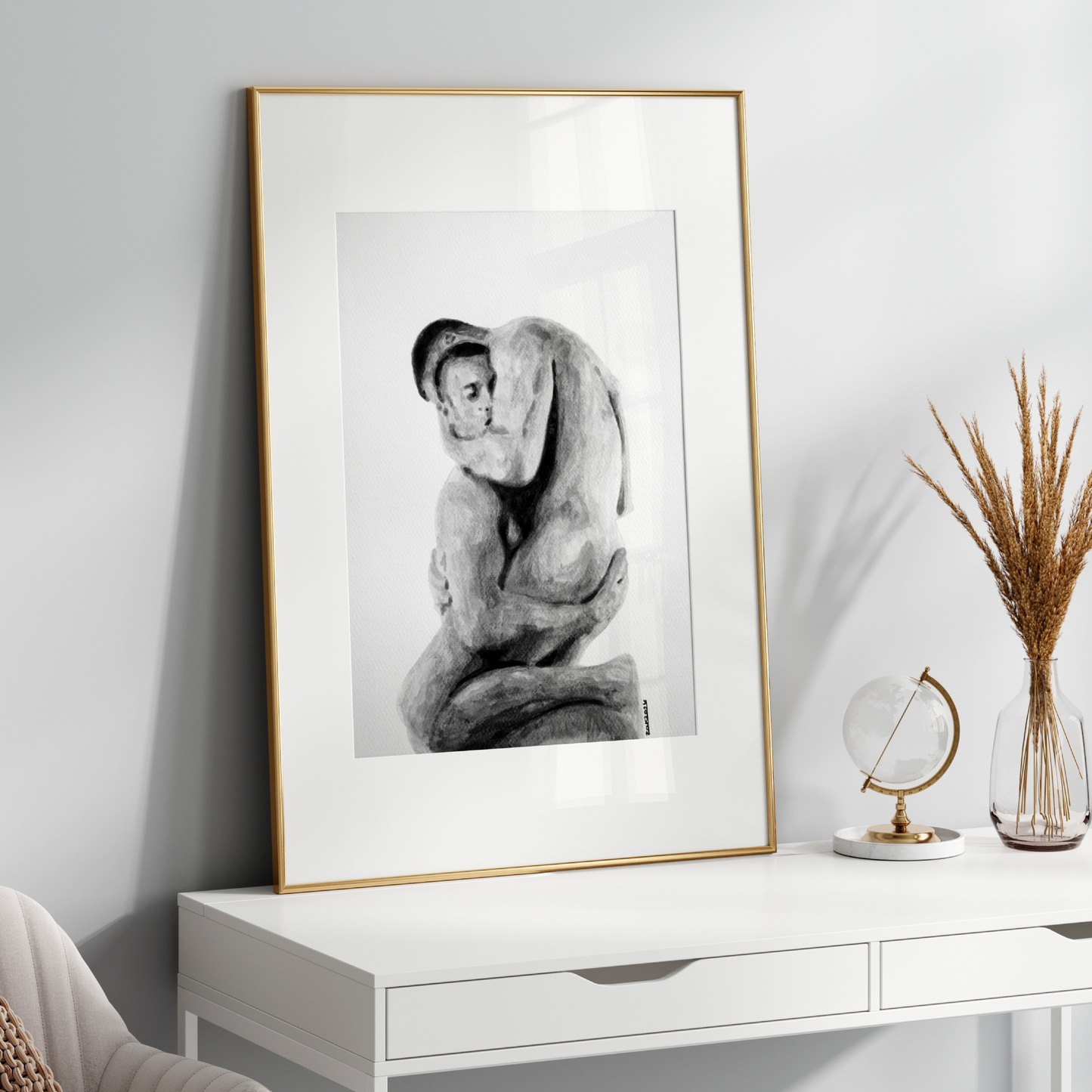 Framed black and white artwork on a white wall above a white console table with decorative items.