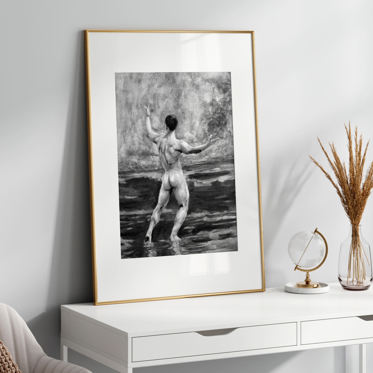 Framed black and white artwork of a nude figure on a white wall above a white console table.