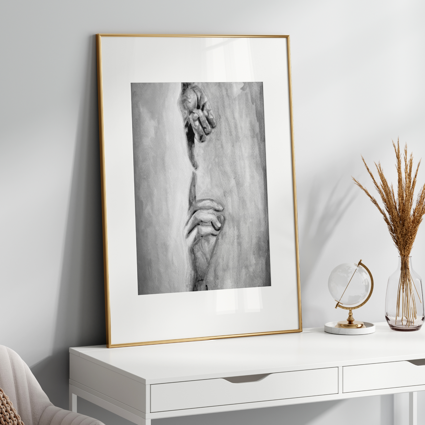Framed black and white artwork on a white wall above a white console table with decorative items.