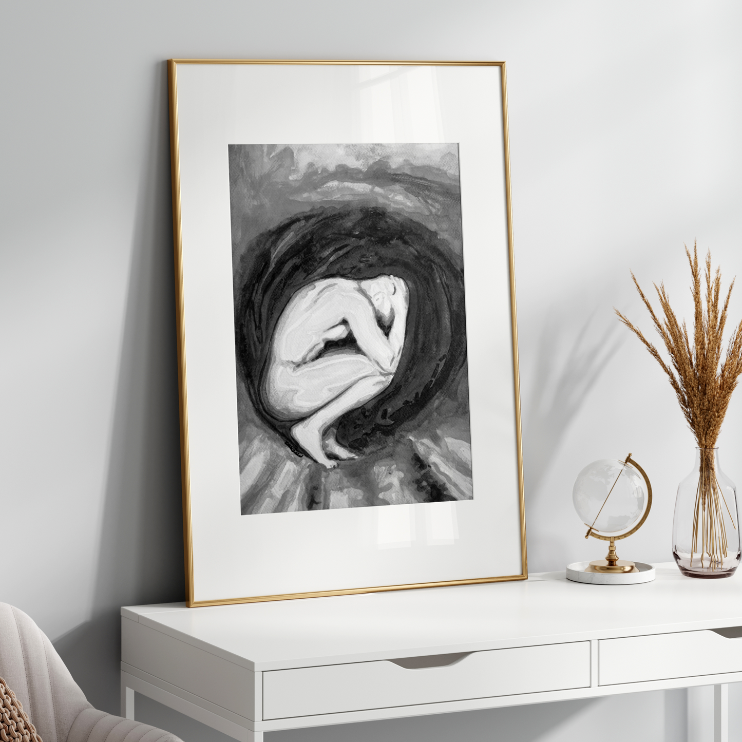 Framed black and white artwork on a white wall above a white console table.
