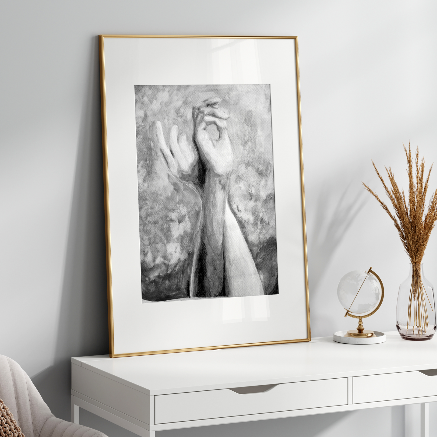 Framed black and white artwork on a white wall above a white console table with decorative items.