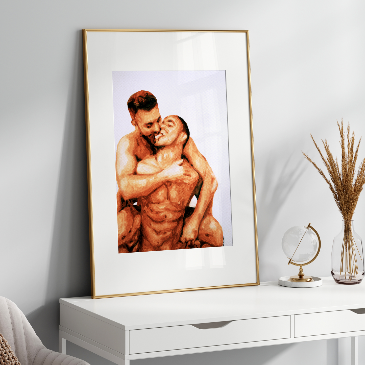 Framed artwork of two people embracing on a white surface with decorative items.