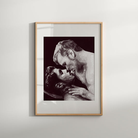 A black and white art print of a same-sex couple kissing, framed in a light wood frame.