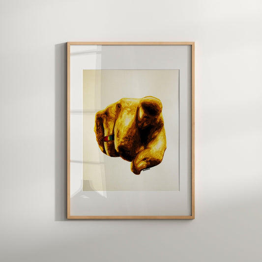 A framed watercolor painting featuring a gold-colored hand making a pointing gesture, with a white background.