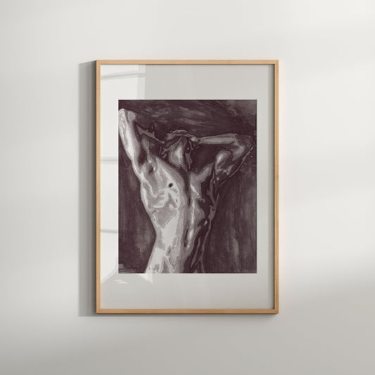 A black and white print of a nude male figure in a contorted pose, framed in a light wood frame.