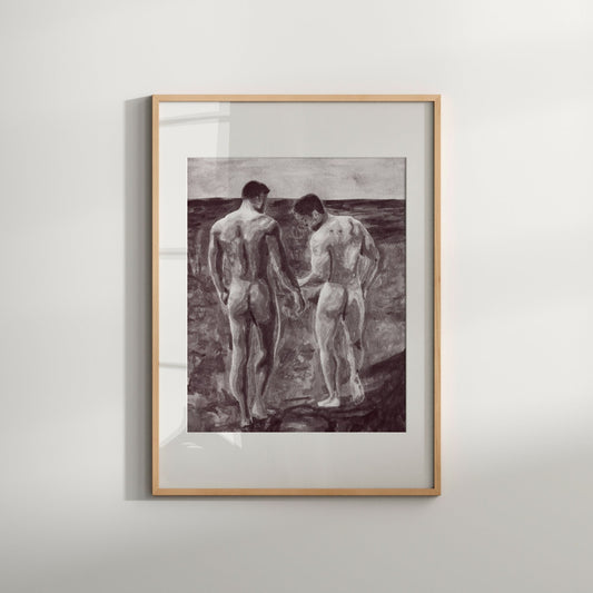 A black and white art print of a sensual nature featuring two nude male figures on a beach, framed in a simple white wooden frame.