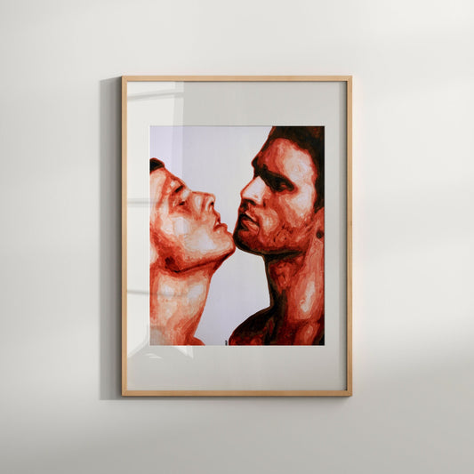 A framed artwork featuring a stylized, erotic depiction of two nude males, with a focus on their faces and bodies. The artwork is in black and white with red accents, set in a simple frame.