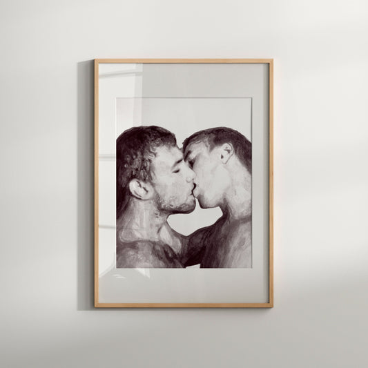 A black and white art print of a gay couple kissing, framed in a light wood enclosure.