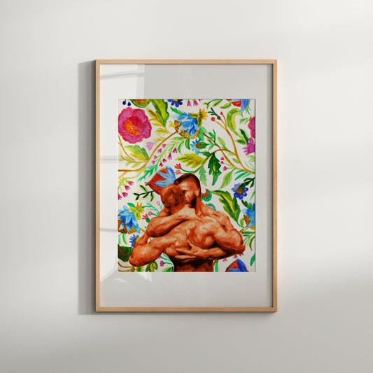 A colorful artistic print featuring a nude male couple embraced with a backdrop of spring flowers, framed in a light wood enclosure.