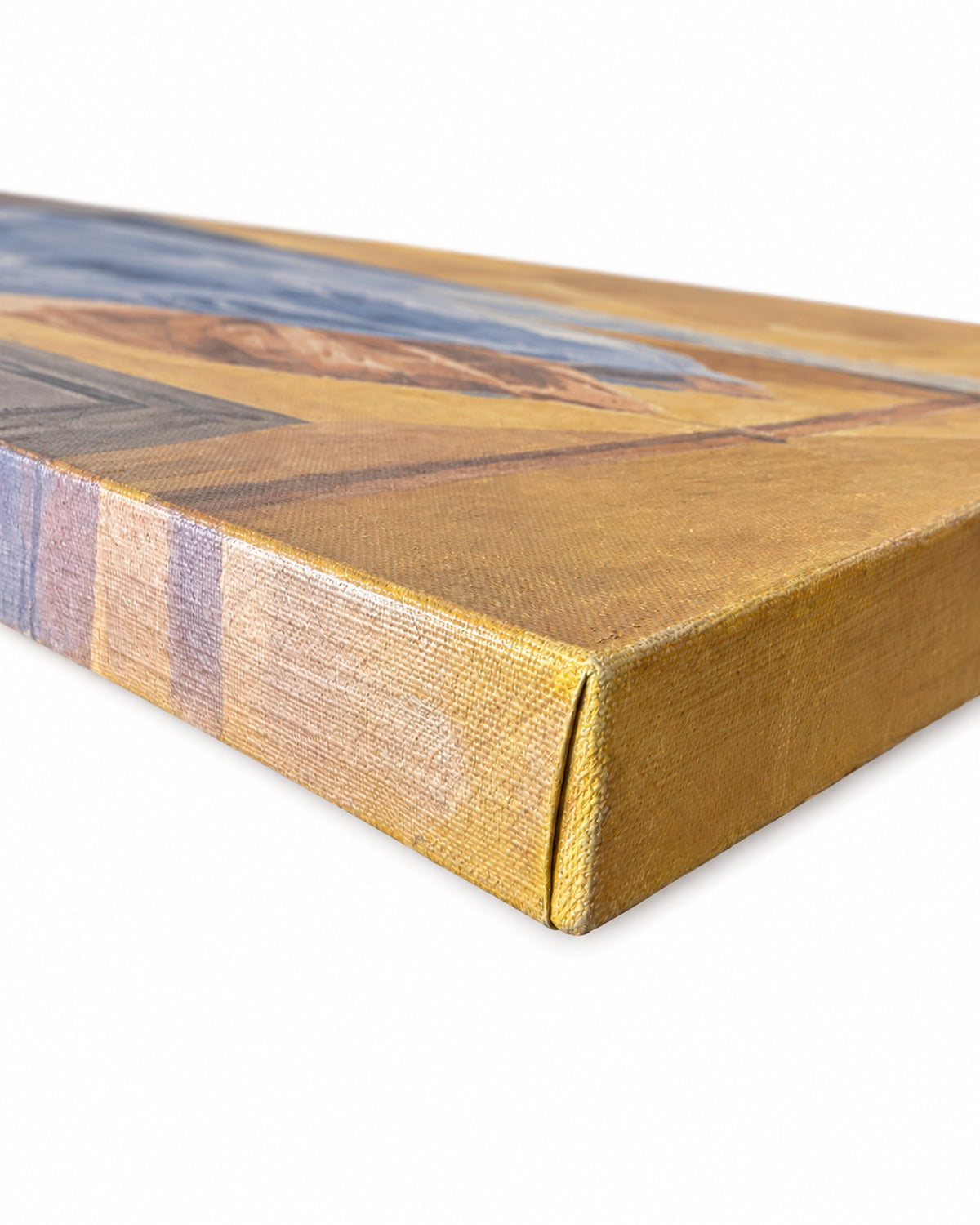 A close-up of a wrapped canvas painting showing its textured golden-yellow fabric edge and a portion of the painted landscape design in blue, brown, and gold tones, set against a plain white background.