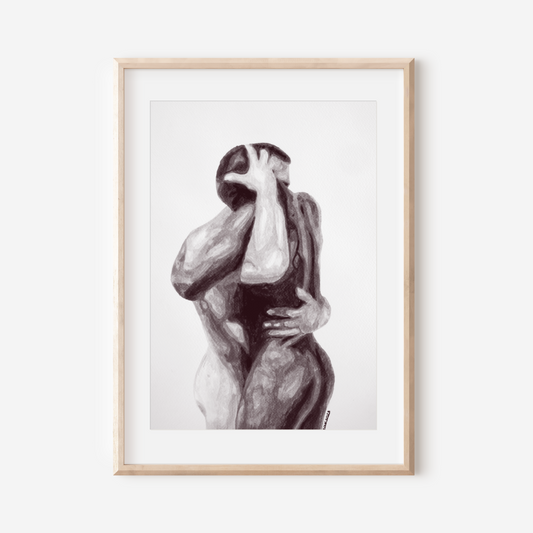 Framed black and white artwork of two abstract figures embracing on a white wall.