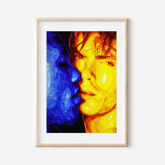Framed artwork of a colorful face split between blue and yellow on a white wall.