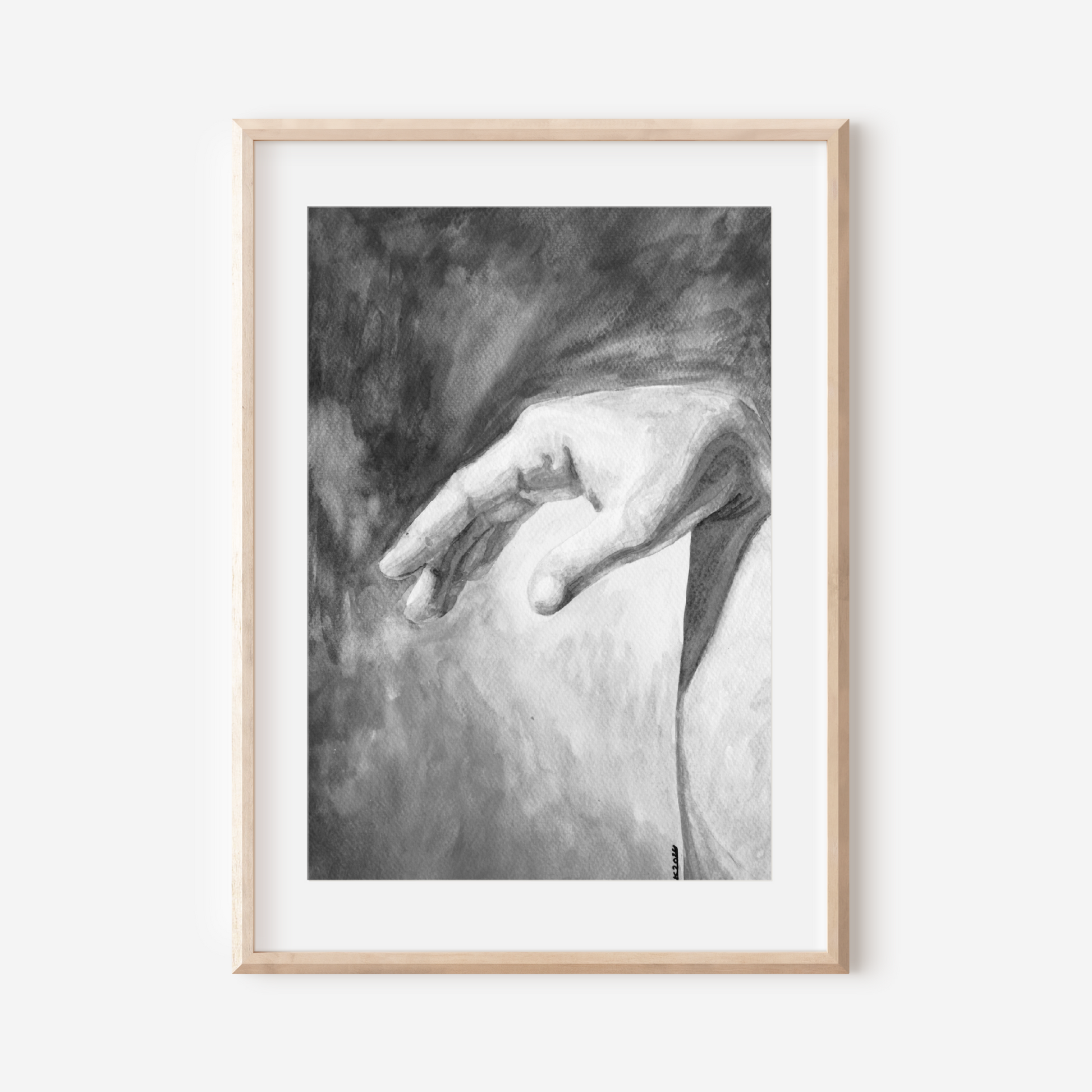 Framed black and white artwork of a hand on a white wall