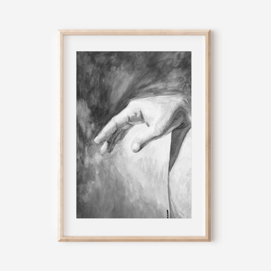 Framed black and white artwork of a hand on a white wall