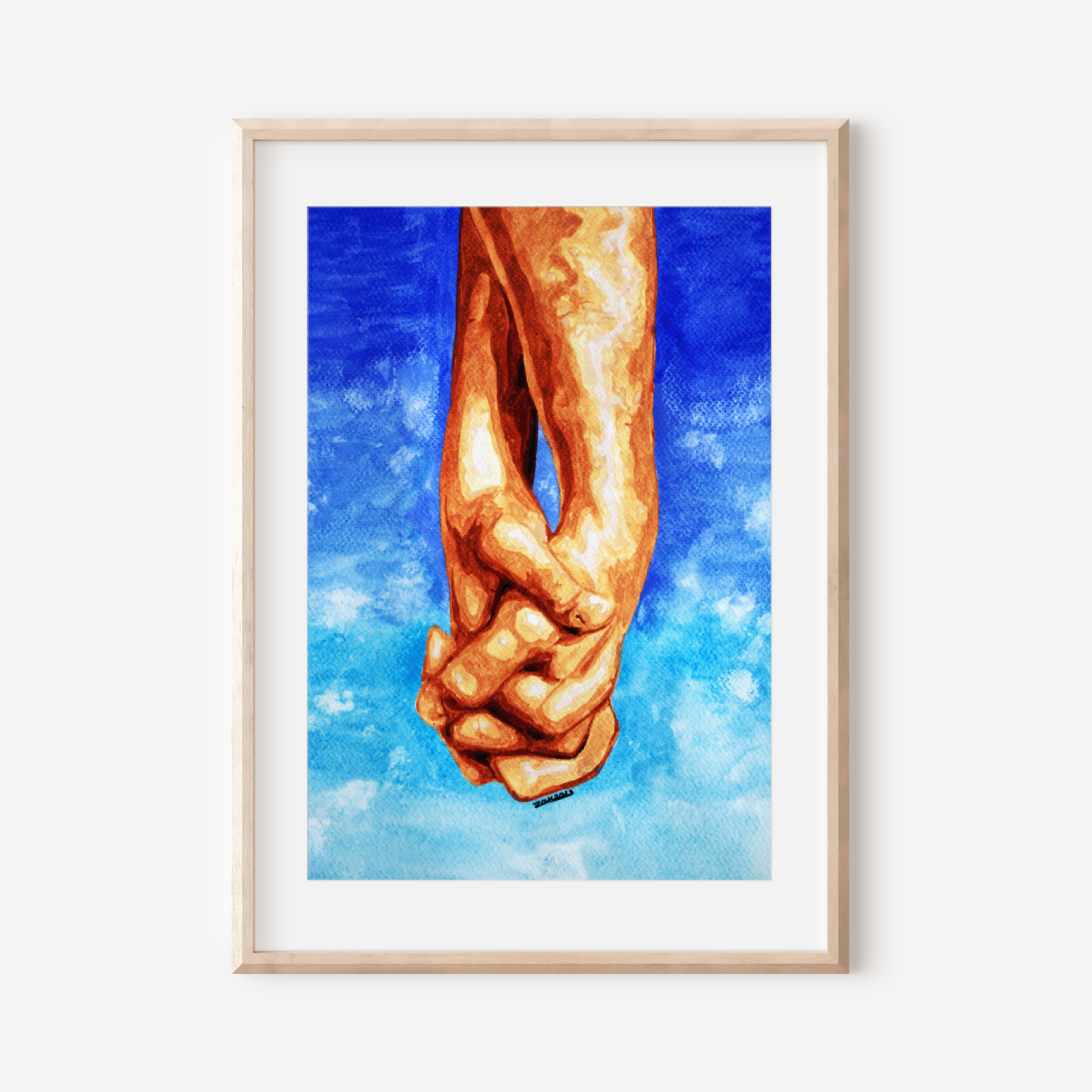 Framed artwork of two hands holding each other against a blue sky with clouds.
