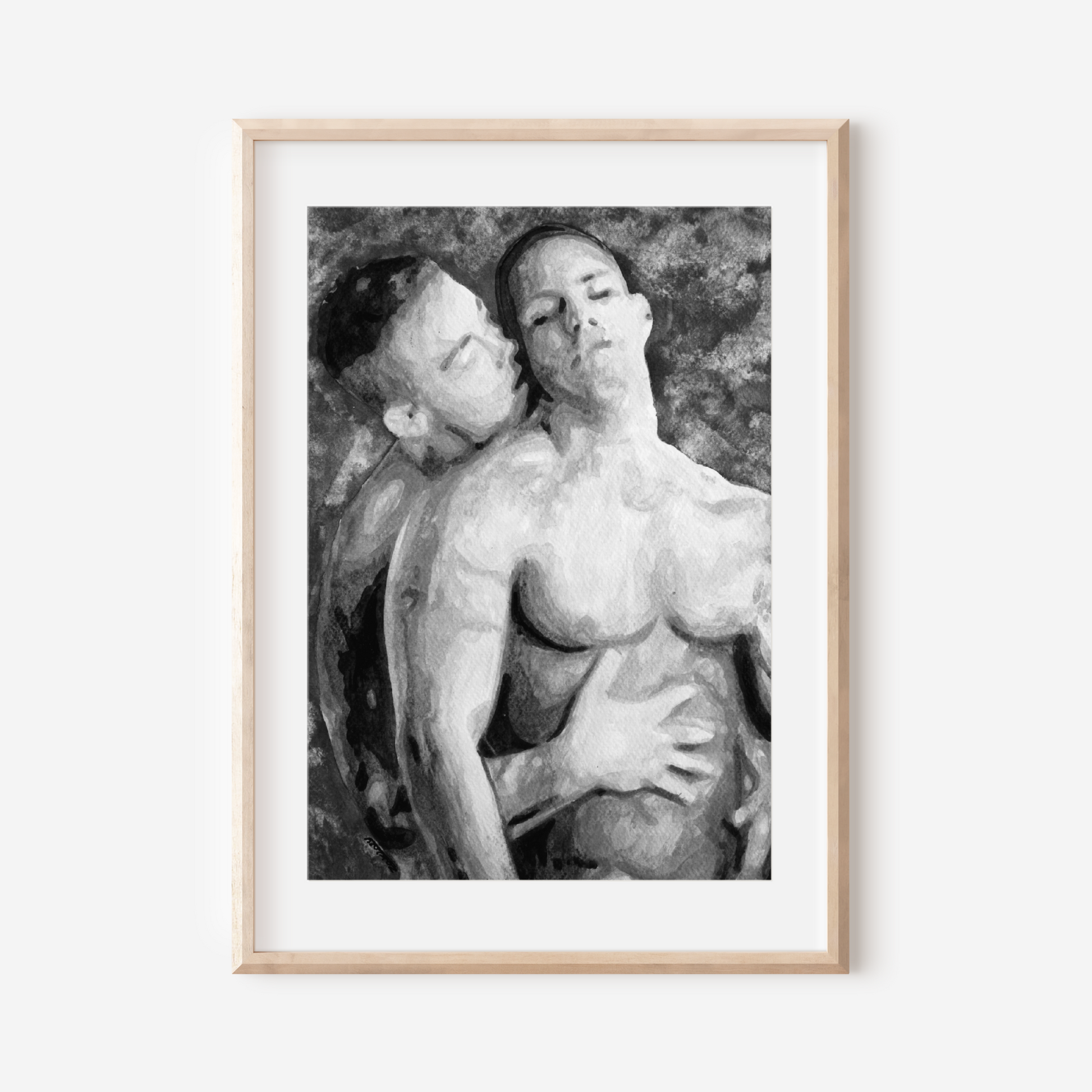 Framed black and white artwork of two nude figures on a white wall